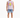 A man stands wearing a sleeveless graphic shirt and distressed denim shorts, paired with white sneakers.