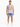 A man stands wearing a sleeveless graphic shirt and distressed denim shorts, paired with white sneakers.