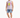 A man stands wearing distressed denim shorts and a sleeveless graphic tee, paired with white sneakers.