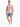 A man stands wearing distressed denim shorts and a sleeveless graphic tee, paired with white sneakers.