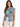 A woman wearing a light blue denim vest over a green top, styled with casual white pants.