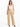 A woman stands confidently in beige high-waisted pants paired with a delicate white lace camisole.