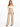 A model poses in wide-leg beige pants paired with a fitted off-the-shoulder top and stylish black heels.