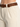 Light beige pants with side pockets, paired with a braided brown leather belt for a stylish look.