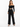 A model wearing tailored black pants paired with a cropped off-the-shoulder top and high-heeled sandals.