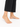 Delicate gold anklet with colorful beads, worn on a bare foot against a white background.