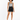A model with curly hair wears a patterned tank top and high-waisted black shorts, paired with black sneakers.