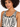 Close-up of a model wearing a patterned bodysuit with a scoop neckline and bold black and white designs.