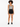A model wearing a patterned bodysuit with black overalls and sneakers, showcasing a casual summer look.