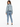 A woman wearing a cropped denim jacket and light blue jeans, standing with her back to the camera.