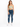 A model wearing a fitted, light green crop top paired with distressed blue skinny jeans and white sneakers.