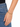 A gold chain bracelet featuring charms of a crescent moon and a star, worn on a wrist against denim.