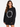 A woman with long, wavy hair wears a black oversized sweatshirt featuring a circular text design in white.
