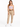 A woman stands confidently in a light purple cropped top, beige high-waisted pants, and white sneakers.