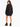 A woman with long hair wears a loose black sweatshirt dress and chunky black heeled boots, facing away.
