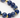 A close-up of a bracelet featuring deep blue spherical beads interspersed with gold hexagonal accents.
