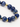 A close-up of a bracelet featuring deep blue spherical beads interspersed with gold hexagonal accents.