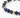 A close-up of a beaded bracelet featuring deep blue stones and gold geometric accents.