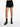 Black shorts with cut-out detailing and chain accents, paired with patterned high-top sneakers and black socks.