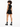 A model with curly hair wears a black sleeveless top and matching shorts, paired with stylish black boots.