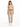 A woman stands wearing a fitted beige top with thin straps, paired with light-colored trousers and white sneakers.