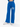 Blue wide-leg pants with an elastic waistband and printed text, paired with white sneakers.
