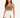 A woman poses in a fitted brown top and a flowing white skirt with high side slits, showcasing a stylish look.