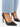 Black high-heeled shoes with a pointed toe, paired with light blue denim, showcasing a sleek and elegant design.