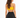 A woman with long, wavy hair wears a yellow crop top and black high-waisted leggings, viewed from the back.