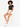 A model with curly hair sits on a stool, wearing a black cropped top and white high-waisted shorts.