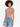 A model with curly hair wears a fitted, short-sleeve, cropped top paired with distressed denim shorts.