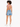 A model with curly hair wears a short-sleeve top with a back cutout, paired with denim shorts and white sneakers.
