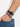 A close-up of a wrist featuring a black beaded bracelet paired with a sleek black watch.