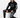 A man sits on a white cube wearing black sweatpants with graphic prints and a matching hoodie, paired with black snea...