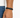 A close-up of a hand wearing a black braided bracelet with a sleek metal clasp, showcasing a minimalist design.