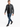 A man walks confidently in a fitted gray leather jacket, paired with a black t-shirt and distressed blue jeans.