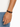 A close-up of a hand wearing a double-stranded brown leather bracelet with a black clasp.
