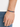 A hand wearing a colorful hexagonal bead bracelet on a black cord, set against a light background.