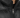 Close-up of a black puffer coat featuring a high collar and a silver zipper, showcasing its sleek design.