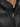 Close-up of a black puffer coat featuring a high collar and a silver zipper, showcasing its sleek design.