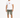 A man stands wearing a white graphic t-shirt and olive green distressed shorts, paired with white sneakers.