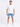A man stands confidently in a fitted white t-shirt paired with light blue denim shorts and white sneakers.