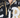 Close-up of a buttoned shirt featuring a black and gold graphic design with bold text and a classic collar.