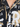 Close-up of a buttoned shirt featuring a black and gold graphic design with bold text and a classic collar.