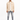 A man stands confidently in a light beige button-up top, paired with distressed gray jeans and white sneakers.