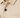 Close-up of a textured beige top featuring a patterned fabric, black buttons, and a classic collar design.