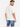 A man wearing a loose-fitting white t-shirt and blue denim shorts, viewed from the back.