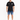A man stands wearing rolled denim shorts, a black t-shirt with graphic text, and stylish sneakers.