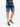 Denim shorts with rolled cuffs, paired with black and white sneakers, showcasing a casual summer look.