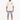A person stands wearing a loose-fitting beige t-shirt and light blue denim shorts, paired with white sneakers.